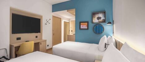 Habitación de hotel con cama, escritorio, silla, televisor y baño visible a través de una puerta abierta.