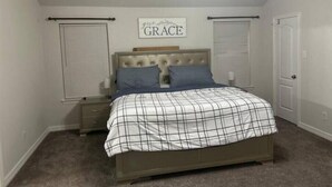 A bedroom with a bed, a ceiling fan, and a sign on the wall.
