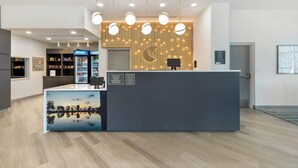A reception desk with a modern design, a digital screen, and a wooden wall with vertical slats.