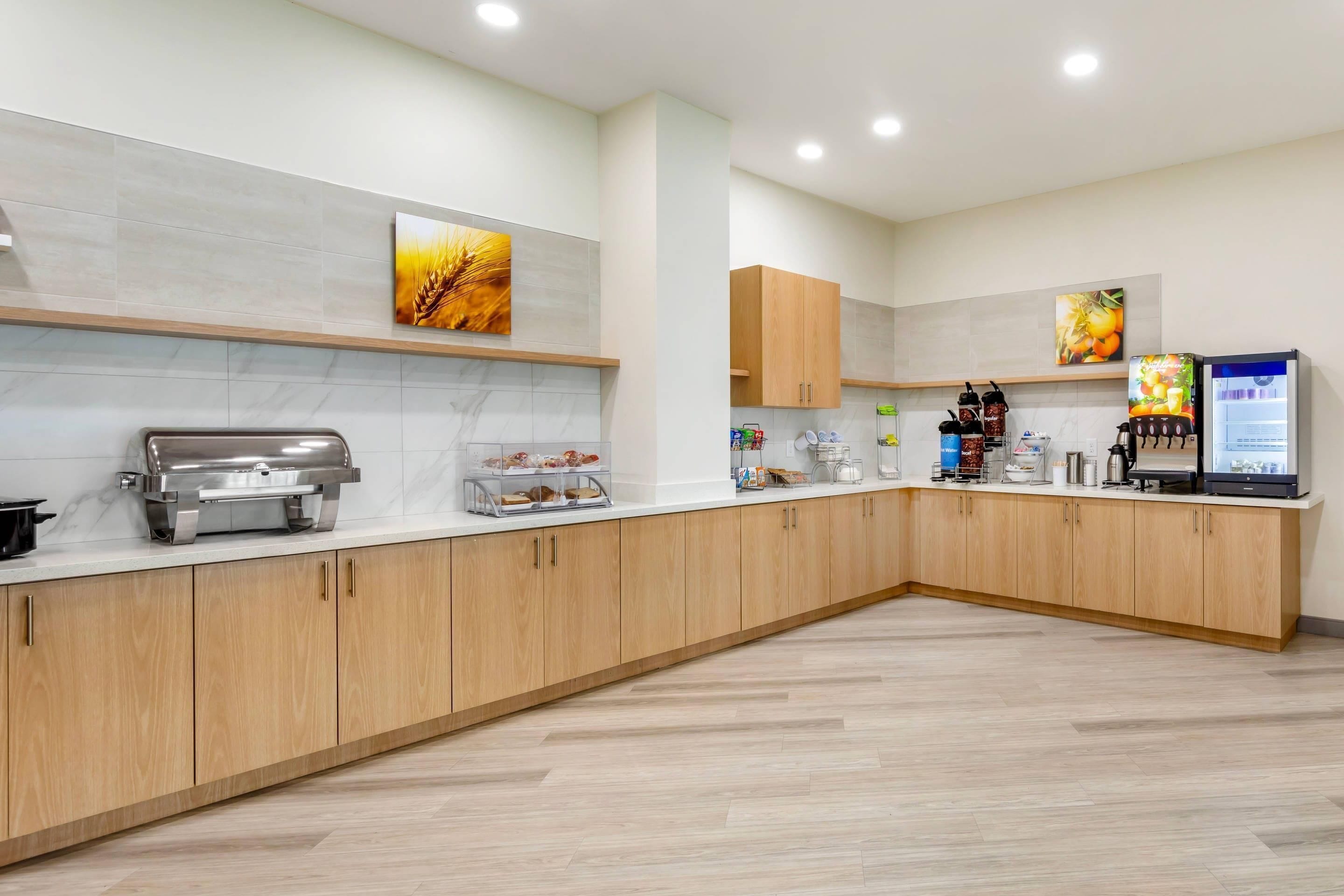 A modern kitchen with wooden cabinets, a stainless steel appliance, and a refrigerator displaying a menu.