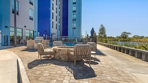 A patio area with outdoor seating, a barbecue grill, and a pool.