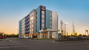 A Comfort Suites hotel with a modern design, featuring a prominent logo on the building.