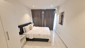 A modern bedroom with a bed, nightstands, a dresser, and a large window with curtains. - The Gem of Embassy Gardens  (Accra)