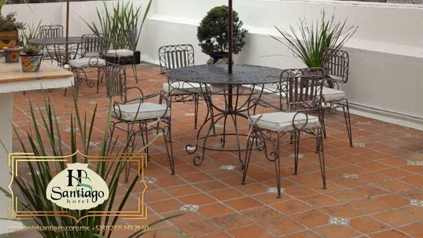 A patio with outdoor seating and a view of historic towers. - HOTEL SANTIAGO (Puebla)