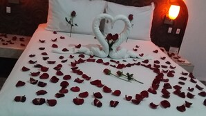 A bed with rose petals and a heart-shaped swan decoration. - HOTEL SANTIAGO (Puebla)