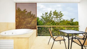 Un balcon avec un évier blanc, une table en verre et deux chaises.