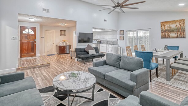 A modern living room with grey sofas, a marble coffee table, and a ceiling fan. - Spacious 3-bedroom house in beautiful Houston with AC (Houston)