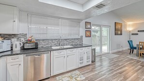 A modern kitchen with white cabinets, a granite countertop, and stainless steel appliances. - Spacious 3-bedroom house in beautiful Houston with AC (Houston)