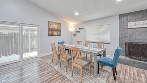 A dining area with a large table, wooden chairs, and a blue upholstered chair. - Spacious 3-bedroom house in beautiful Houston with AC (Houston)
