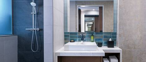 A modern bathroom with a shower, a sink, and a mirror.