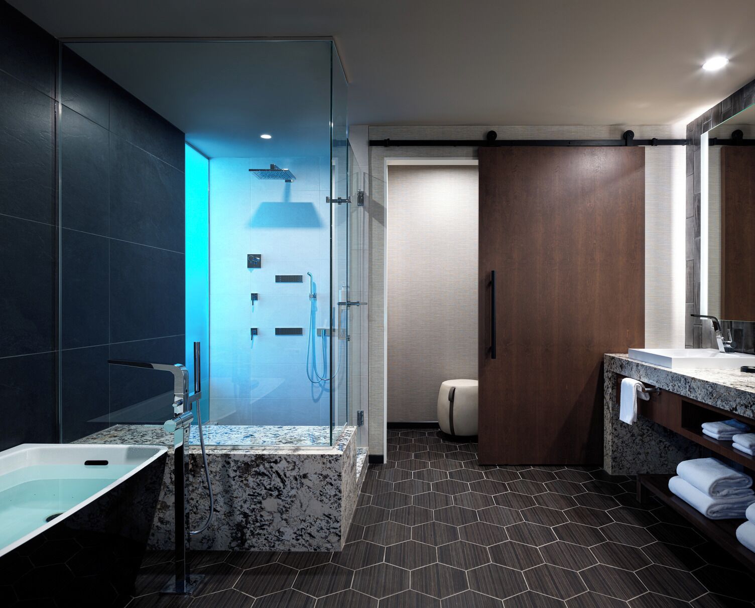 A modern bathroom with a glass-enclosed shower, a marble sink, and a wooden vanity.