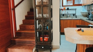 Eine Treppe führt zu einer Küche mit Holzausstattung und einer eingebauten Bücherwand.
