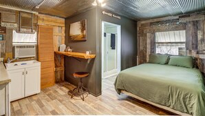 A rustic room with a bed, a kitchen area, and a bathroom. - Starlight Vista w/Fire Pit, Grill & Mountain Views (Jasper)