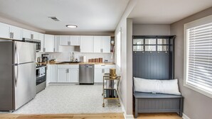 A modern kitchen with white cabinets, stainless steel appliances, and a built-in dishwasher. - Remote Work Retreat: 3BR w/ Workspace Near KC! (Olathe)