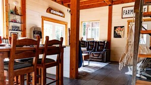 A rustic interior with wooden furniture, a fireplace, and a farm-themed wall sign.