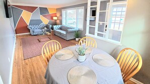 A dining area with a round table, chairs, and a decorative centerpiece.