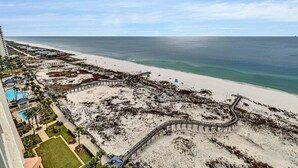 Ein Strandresort mit einer Holzpromenade, einem Pool und Blick auf den Ozean.