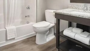 Une salle de bain avec douche, toilettes et lavabo.