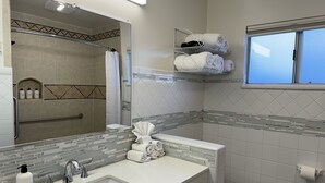 A bathroom with a sink, mirror, towel rack, and a window. - Eastern Sierra Motor lodge (Independence)