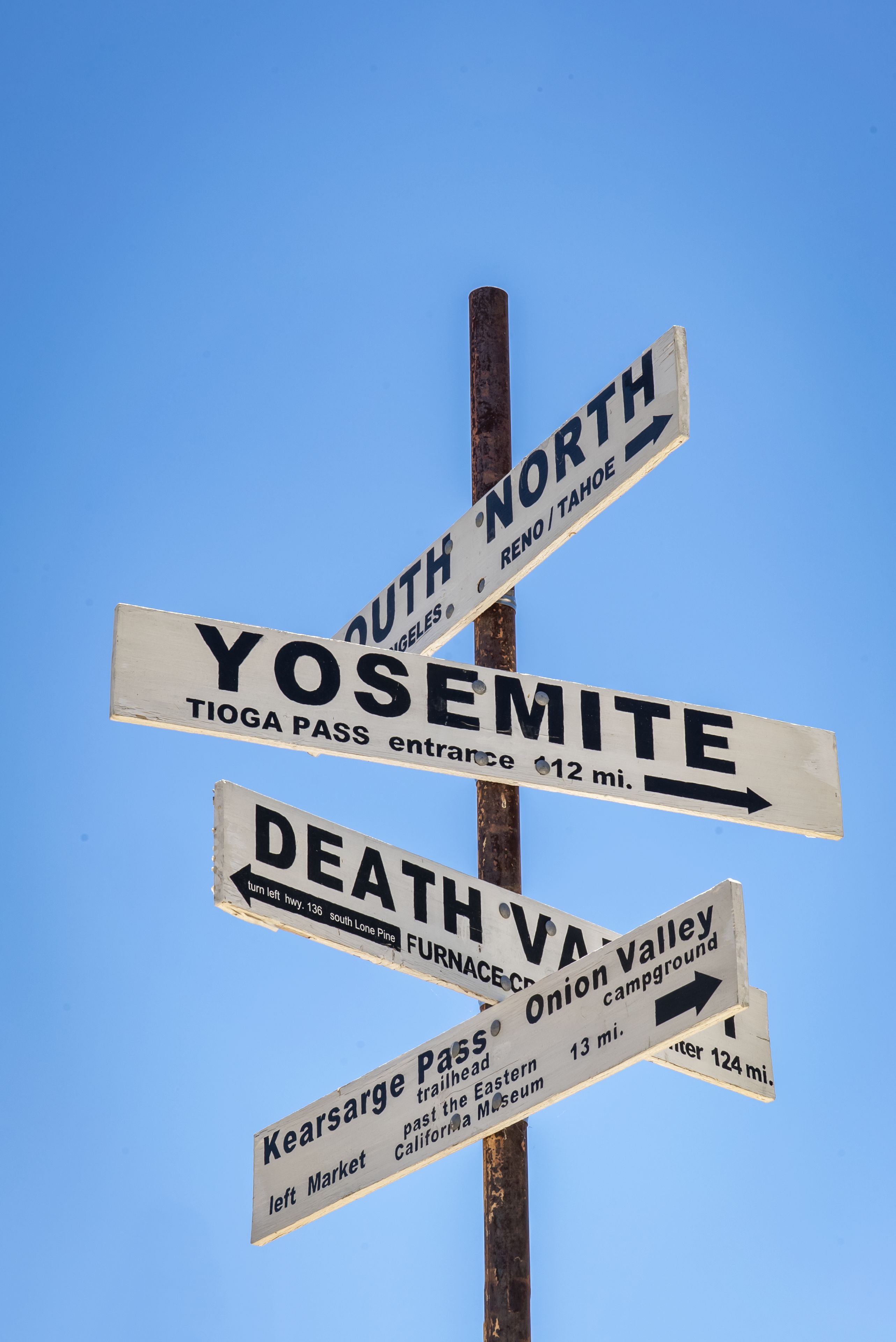 A directional signpost with multiple signs pointing to various destinations.
