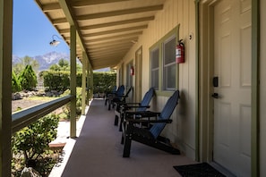 A covered porch with outdoor seating and a fire extinguisher mounted on the wall.
