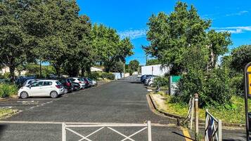 Un estacionamiento con automóviles y una entrada con portón.