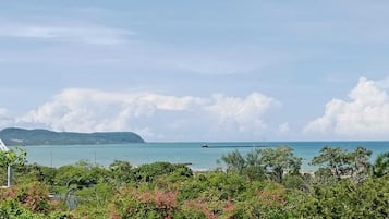 Vista costera con cielo despejado, una isla distante y una masa de agua.