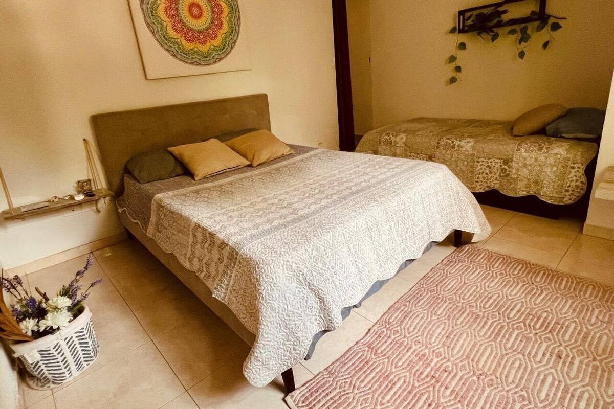 Ein Schlafzimmer mit einem Bett, einem Nachttisch, einer Wandablage und einer dekorativen Wandgestaltung.