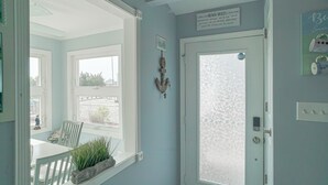 Una habitación con un ventanal grande, una puerta con vidrio esmerilado y un letrero encima de la puerta.