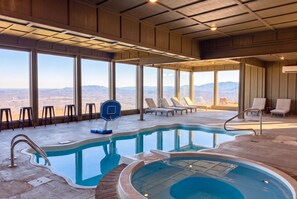 An indoor swimming pool with a basketball hoop, lounge chairs, and a view of the mountains. - 360 Views~Indoor Pool~Theater~Game Room~Mini Golf~Fireplaces (Sevierville)