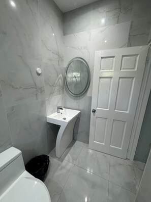 Ein Badezimmer mit Toilette, Waschbecken und Tür.