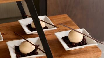 Three square white dishes with chocolate cake and a scoop of vanilla ice cream, each with a chocolate stick.