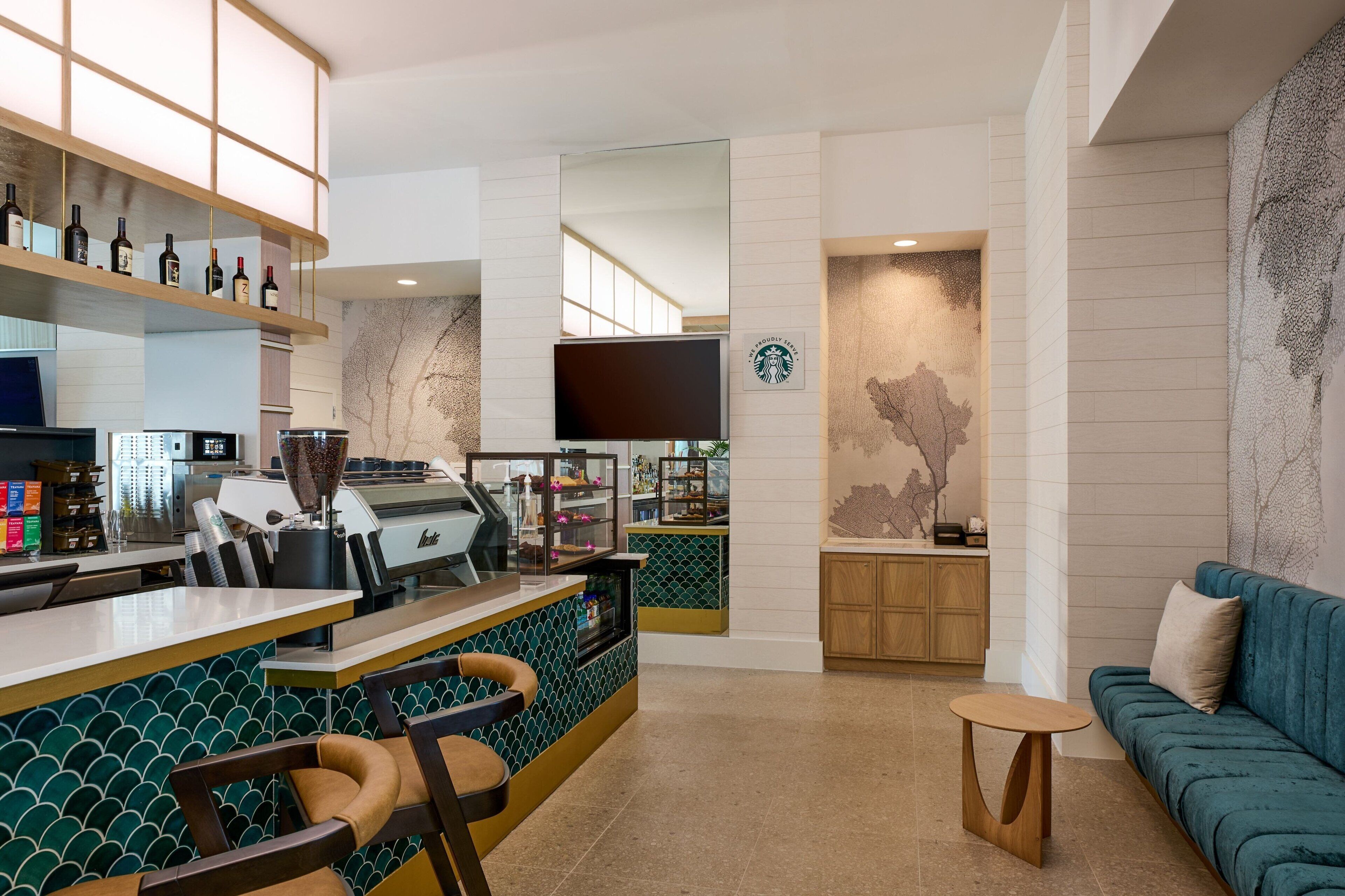 A modern bar area with a counter, seating, and a large screen.