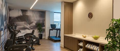 A modern gym with exercise equipment, a treadmill, and a weight bench.