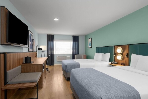 A hotel room with a bed, a desk, a chair, a television, and a window with curtains. - Wingate by Wyndham Farmington NM (Farmington)