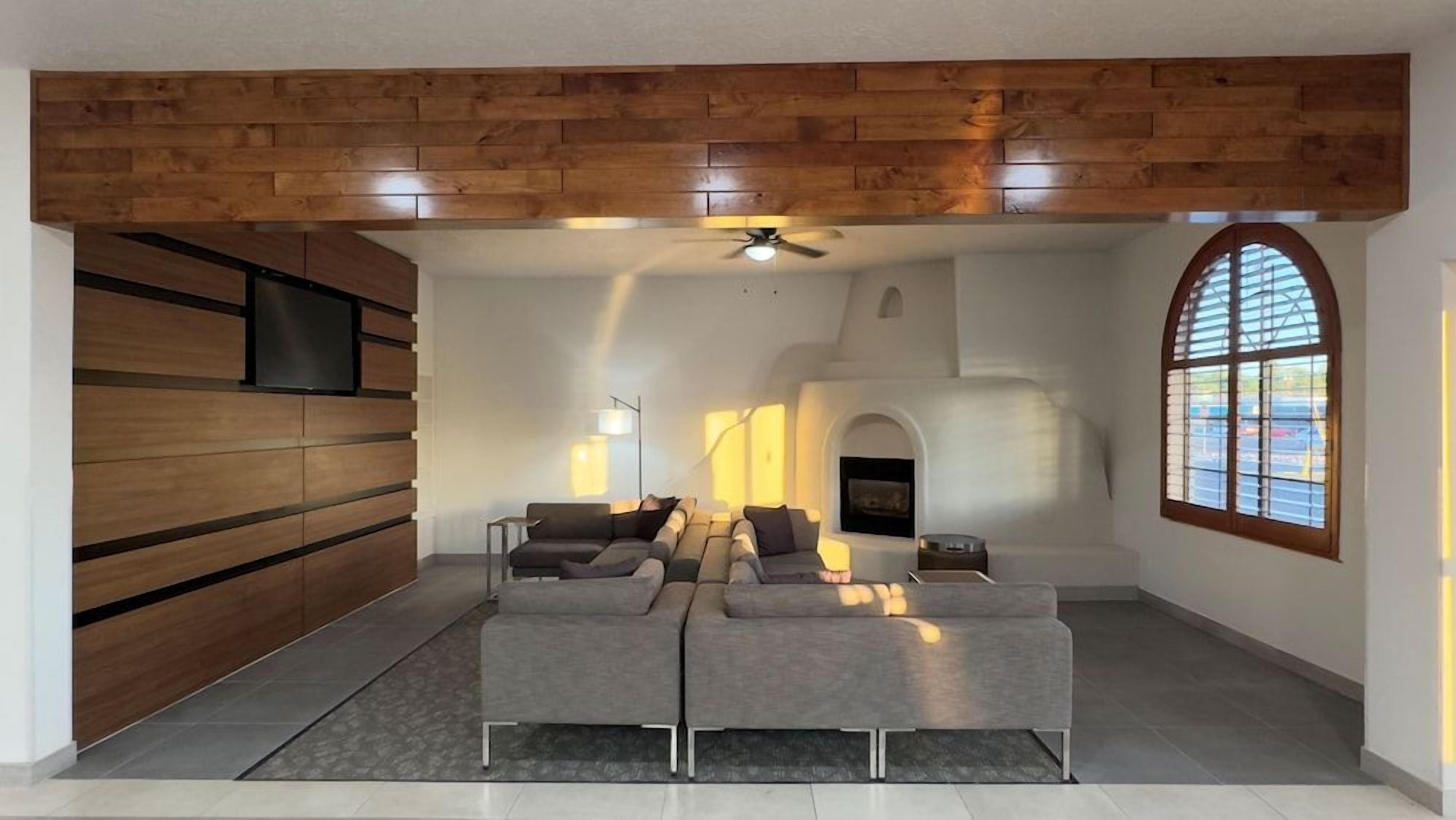 Una sala de estar moderna con un sofá modular, una chimenea y una pared decorativa de madera.