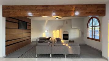 Una sala de estar moderna con un sofá modular, una chimenea y una pared decorativa de madera.