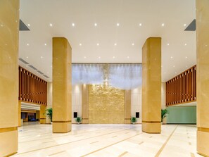 A spacious lobby with high ceilings, large columns, and a modern chandelier. - Holiday Inn Express Beijing Conference Center (Beijing)