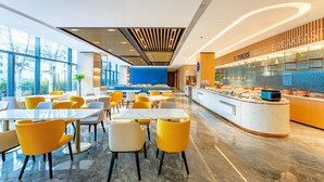 A modern hotel lobby with a breakfast bar, seating area, and large windows. - Holiday Inn Express Beijing Conference Center (Beijing)