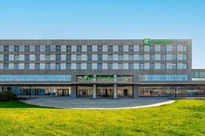 Ein Holiday Inn Express Gebäude mit modernem Design, das eine große Glasfassade und einen großzügigen Eingangsbereich zeigt.