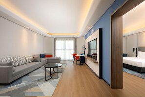Una habitación de hotel moderna con sofá, mesa de comedor y cama.