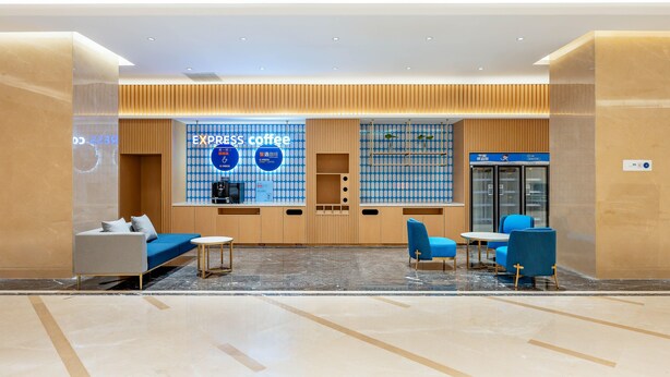 A modern coffee shop with a blue and white color scheme, featuring a sofa, chairs, and a coffee counter. - Holiday Inn Express Beijing Conference Center (Beijing)