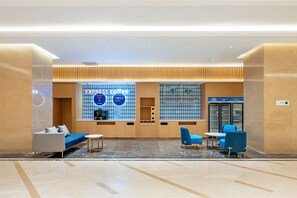 A modern coffee shop with a blue and white color scheme, featuring a sofa, chairs, and a coffee counter. - Holiday Inn Express Beijing Conference Center (Beijing)