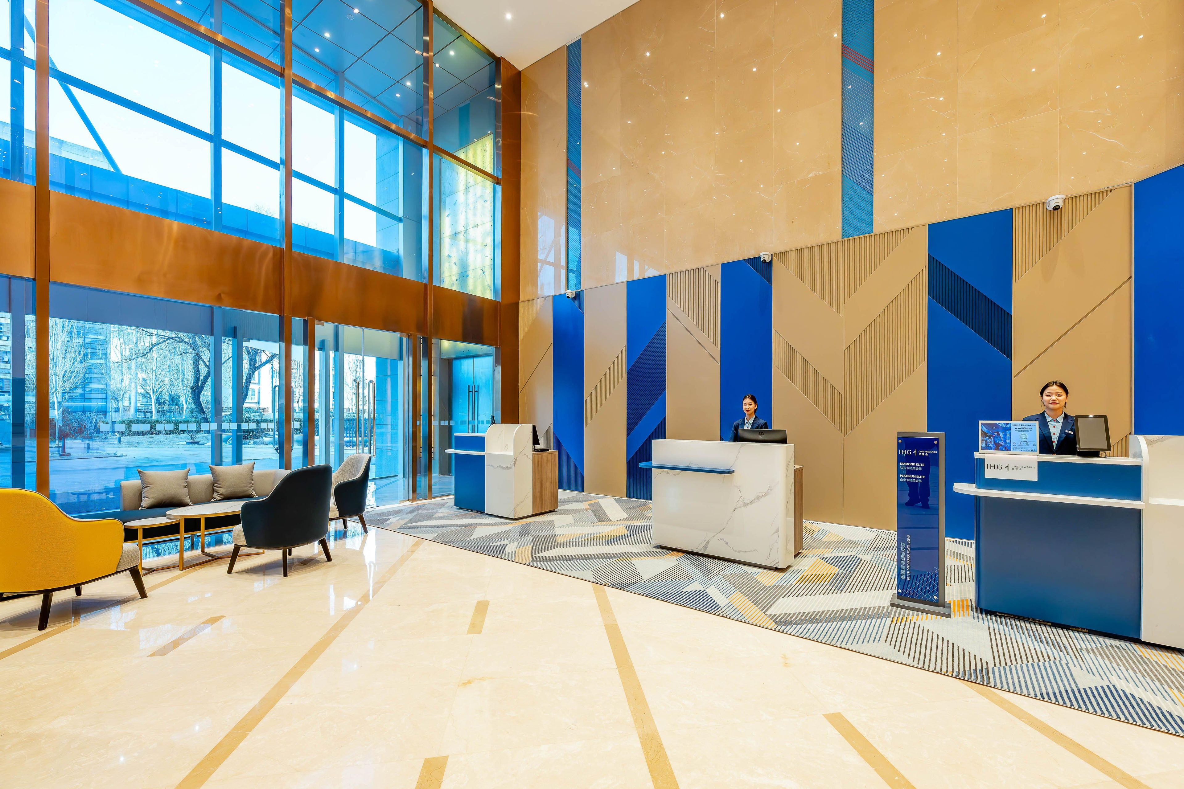 Eine moderne Lobby mit Empfangstresen, Sitzgelegenheiten und großen Fenstern.