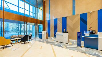Eine moderne Lobby mit Empfangstresen, Sitzgelegenheiten und großen Fenstern.
