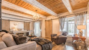 Un salon chaleureux avec un canapé, un fauteuil et une cheminée.