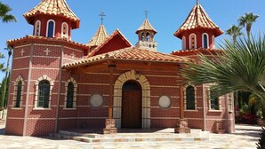 Una iglesia de ladrillo rojo con múltiples torres abovedadas y una entrada central.