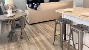 Une cuisine moderne avec un coin repas, un ventilateur de plafond et un téléviseur à écran plat.