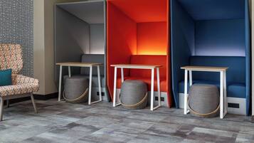 A modern room with a patterned chair, a small table, and three colorful partitions.