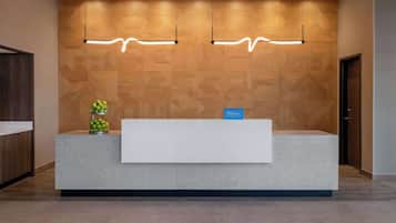 Un mostrador de recepción de hotel con una pared de madera y dos lámparas colgantes.